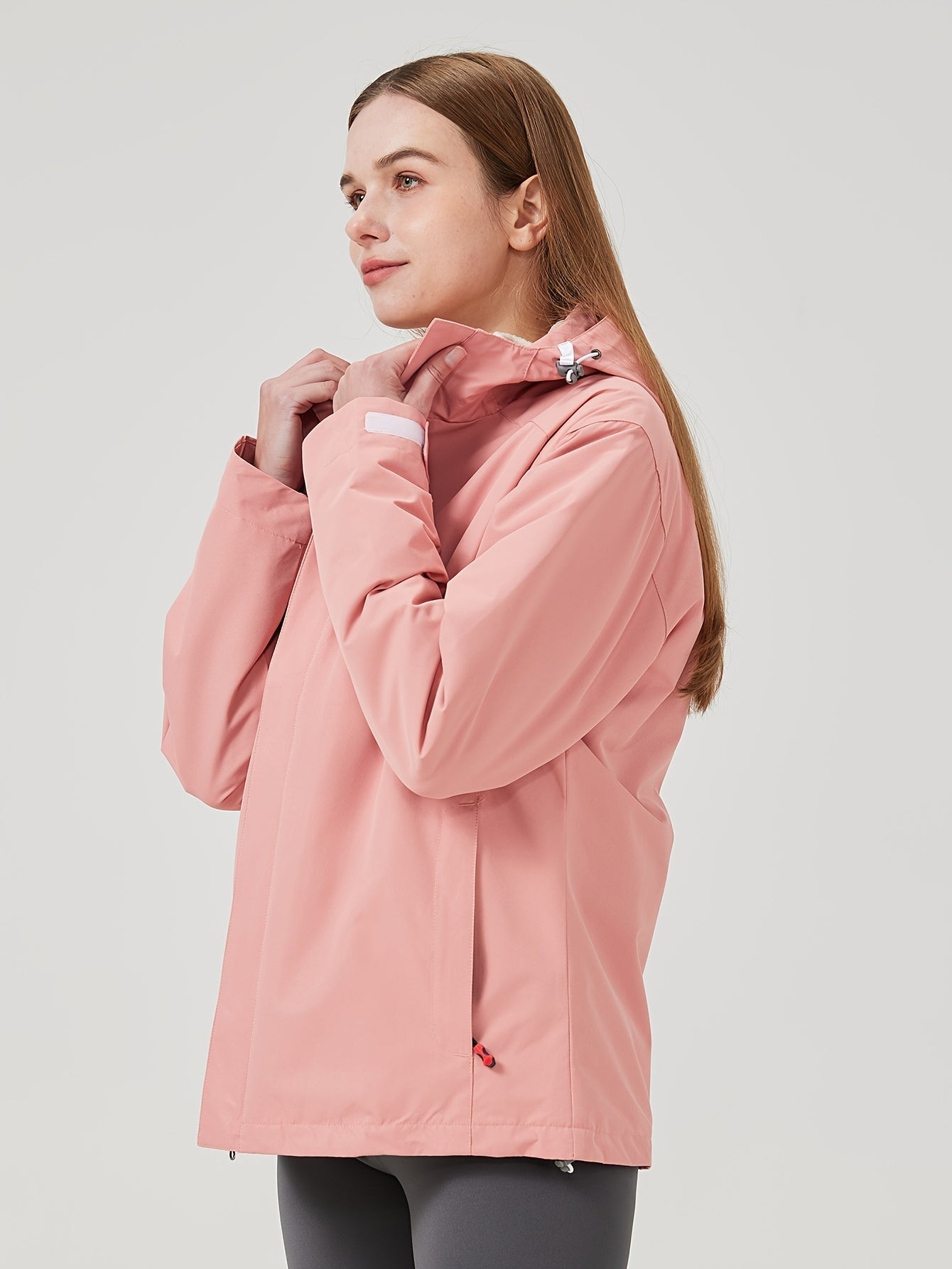 Woman wearing a pink jacket on a light gray background