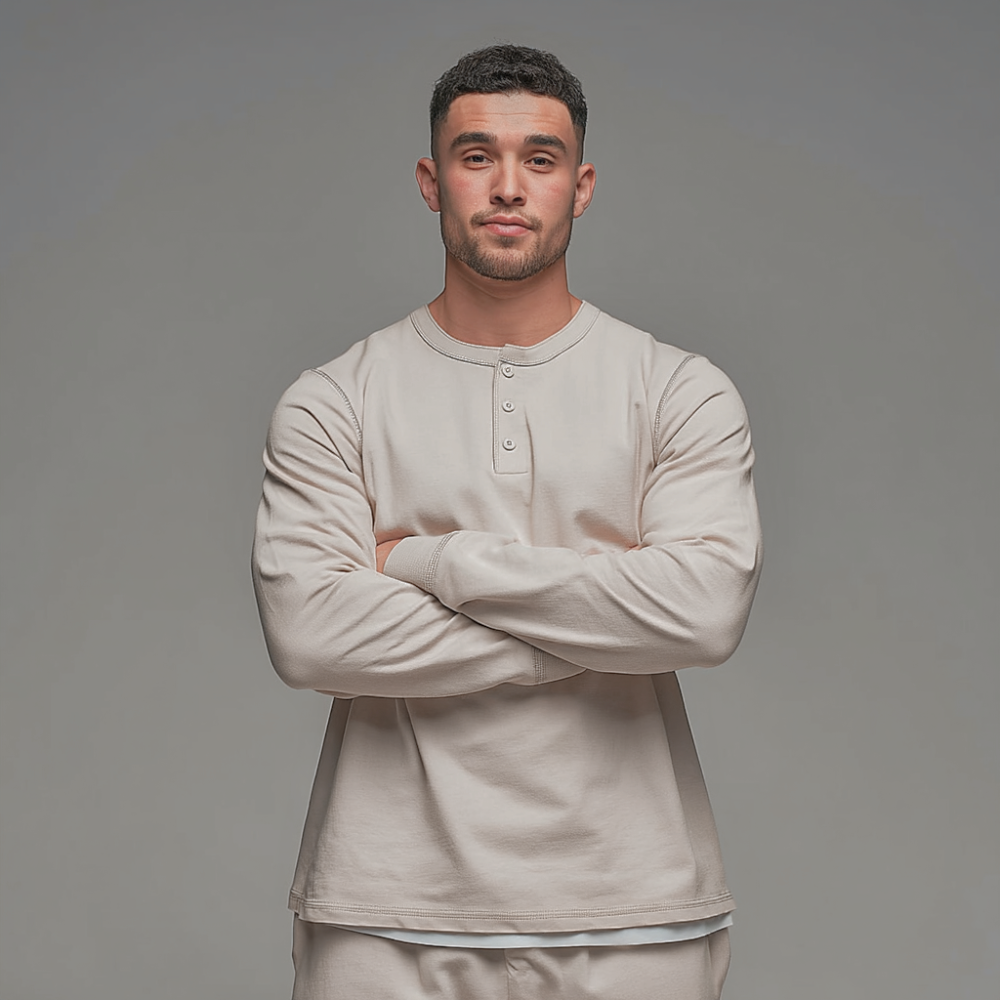 Man wearing a beige long-sleeve shirt against a gray background
