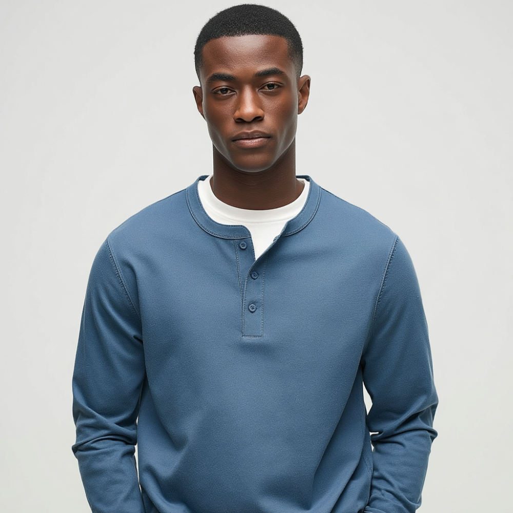 Man wearing a blue long-sleeve shirt with a white collar against a gray background