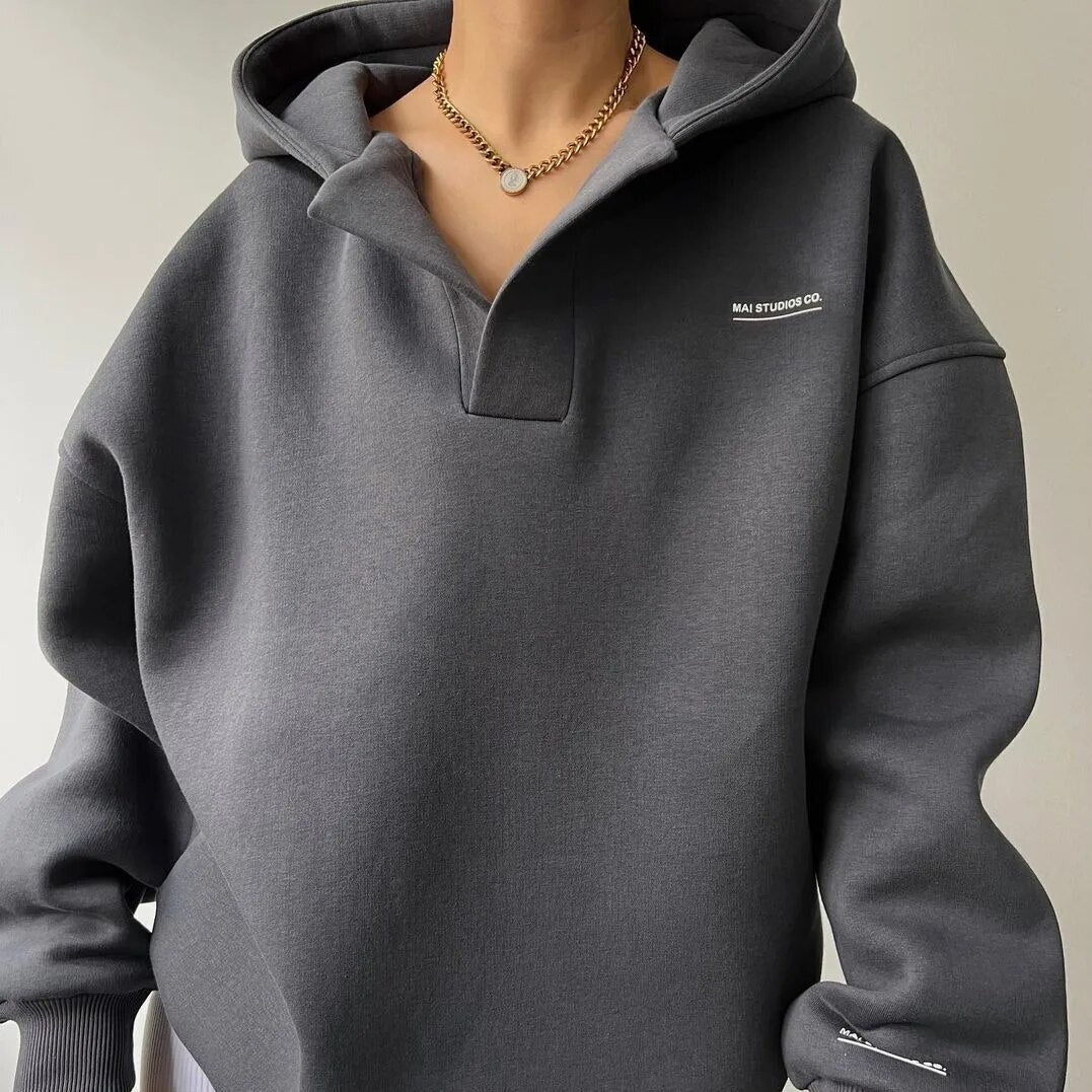 Gray hoodie with a brand logo on a neutral background