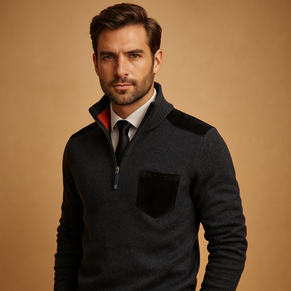 Man wearing a dark gray sweater with a beige background
