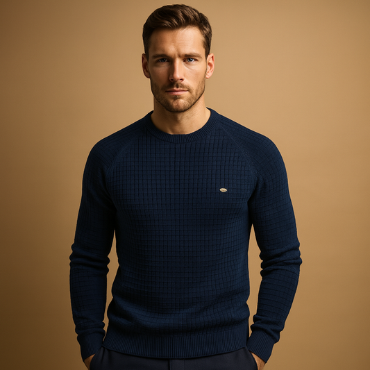 Man wearing a navy blue sweater against a beige background