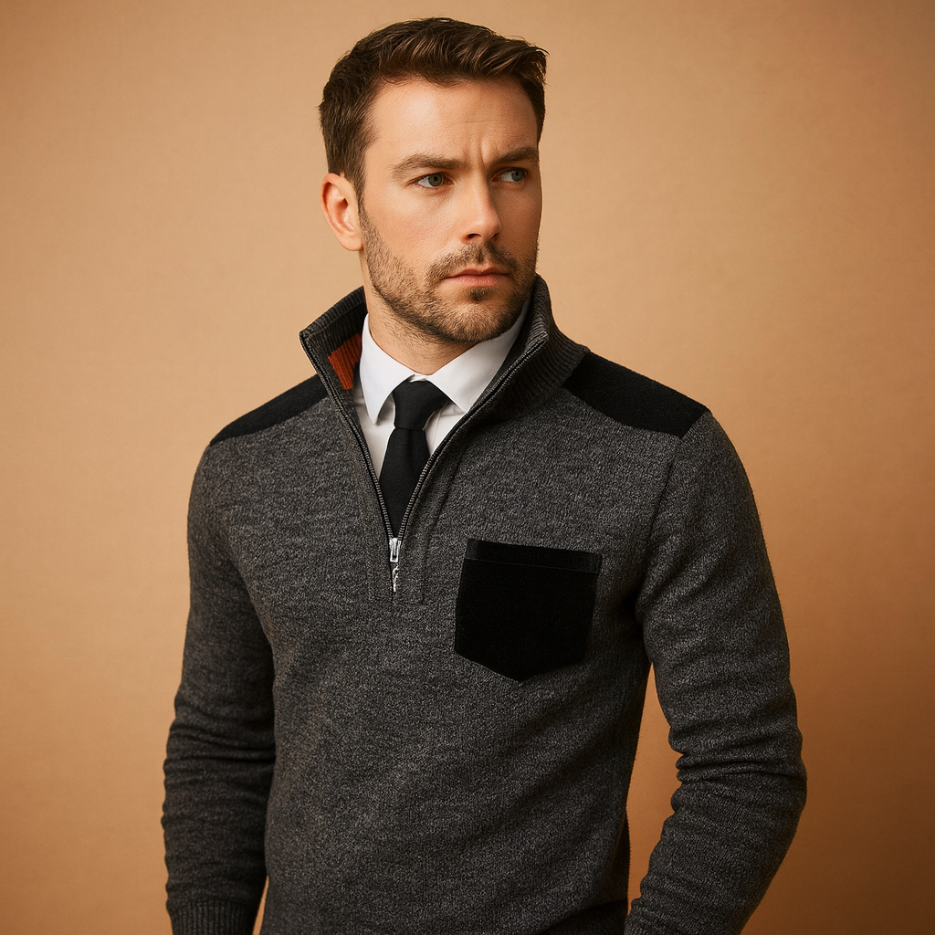 Man wearing a gray sweater with black accents against a beige background