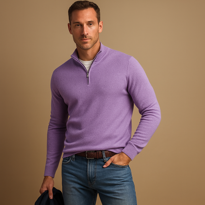 Man wearing a purple quarter-zip sweater and blue jeans against a beige background
